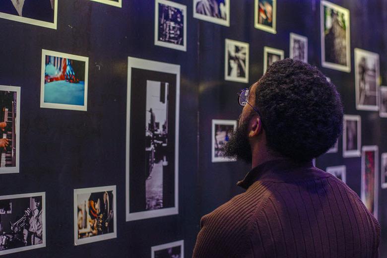 A man looks at photographs on the walls of The Dark Room at The Grandel.