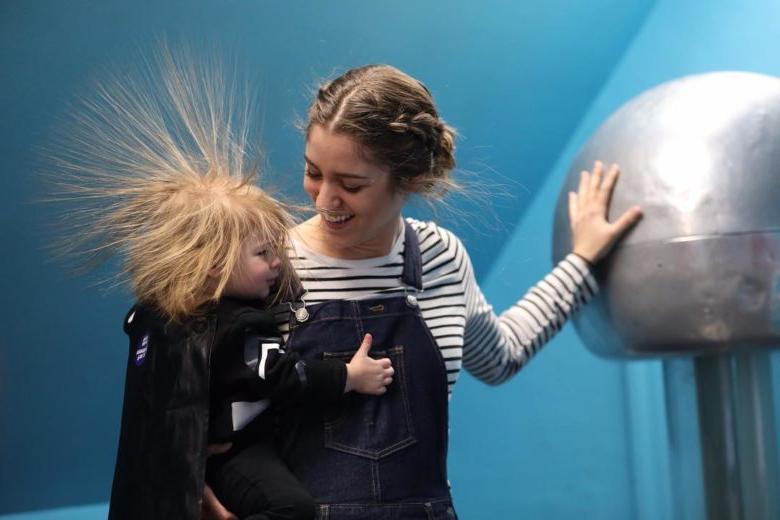 在魔法屋, 有孩子的家庭通过触摸一个带电的球让头发竖起来.