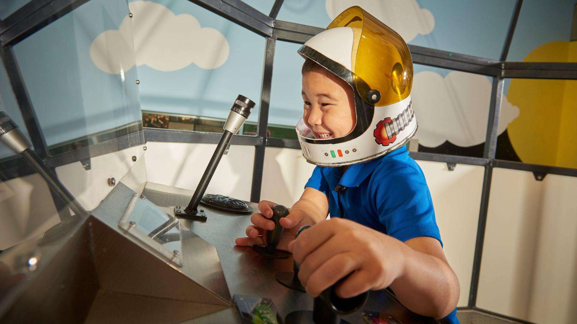 在圣路易斯科学中心，一个小男孩假装自己是宇航员.
